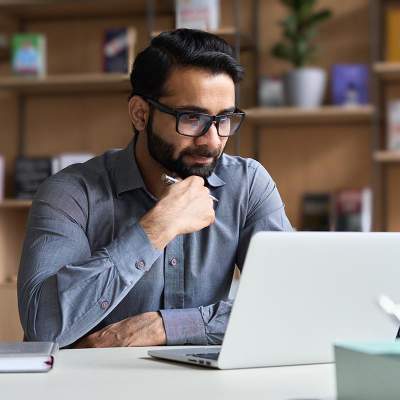 man with glasses using laptop